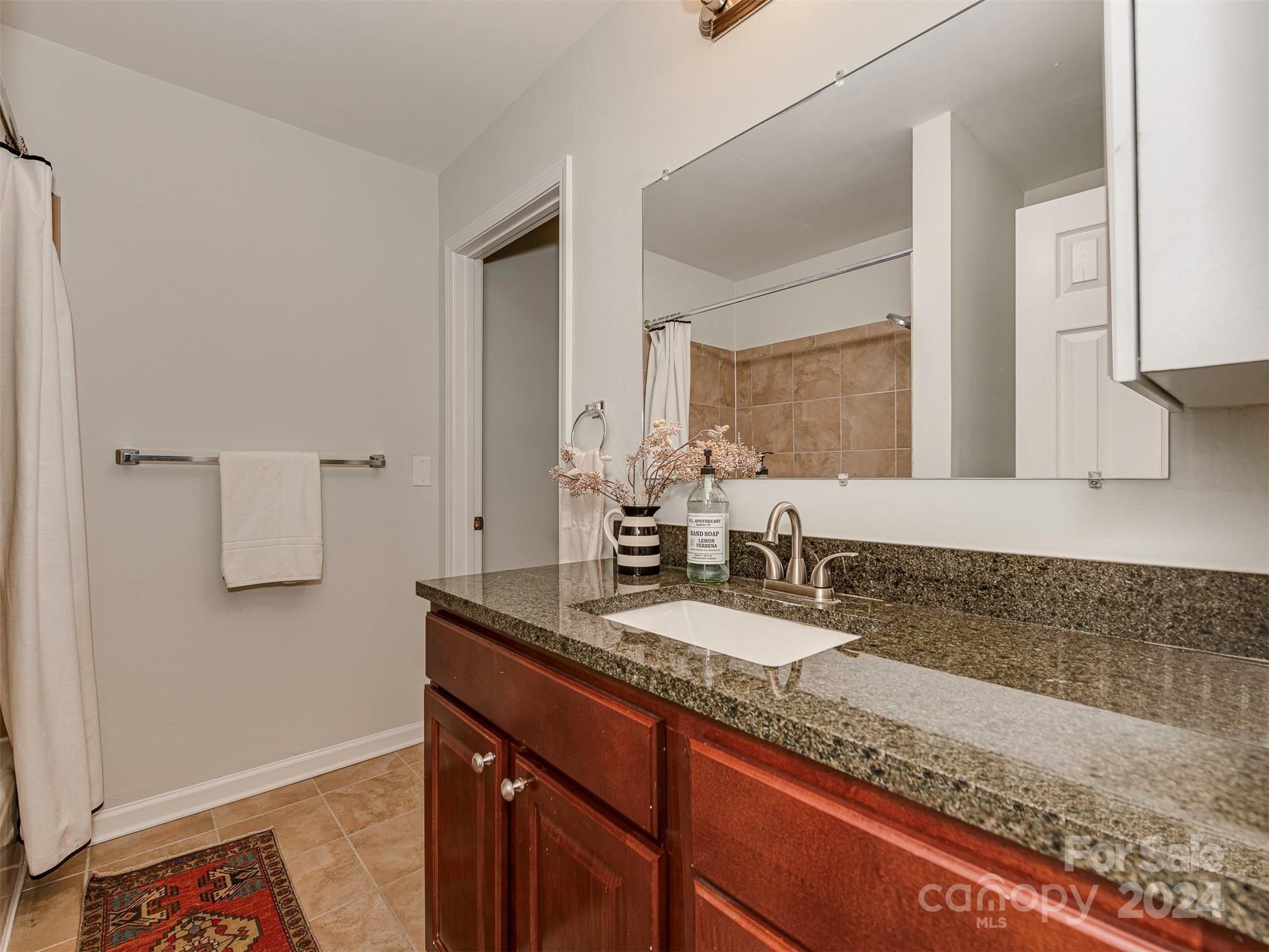 5541 Toano Road Charlotte, NC 28215 - Photo 18 of 35 a bathroom with a granite countertop sink and a mirror