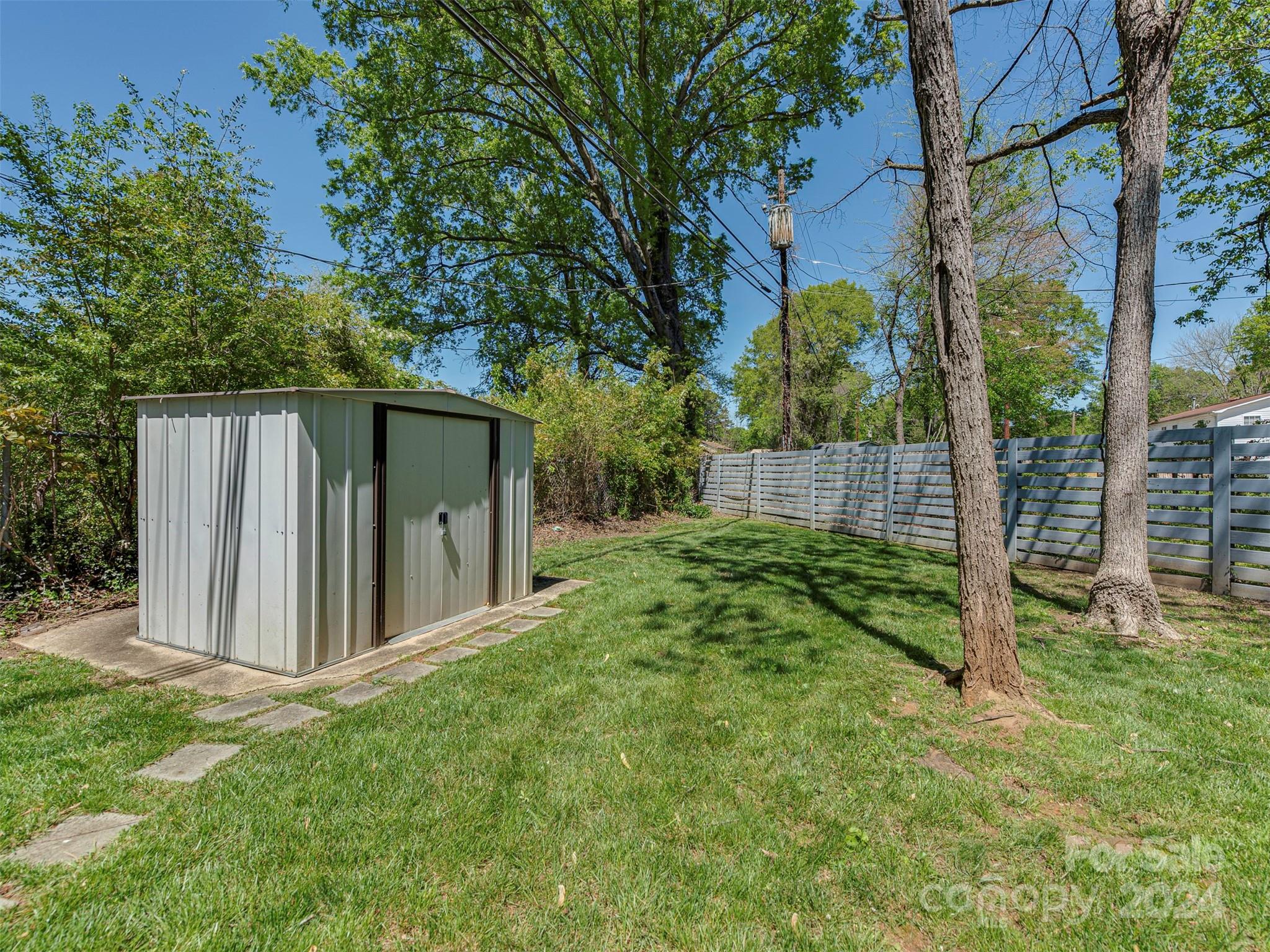 5541 Toano Road Charlotte, NC 28215 - Photo 32 of 35 a view of a backyard with large trees and wooden fence