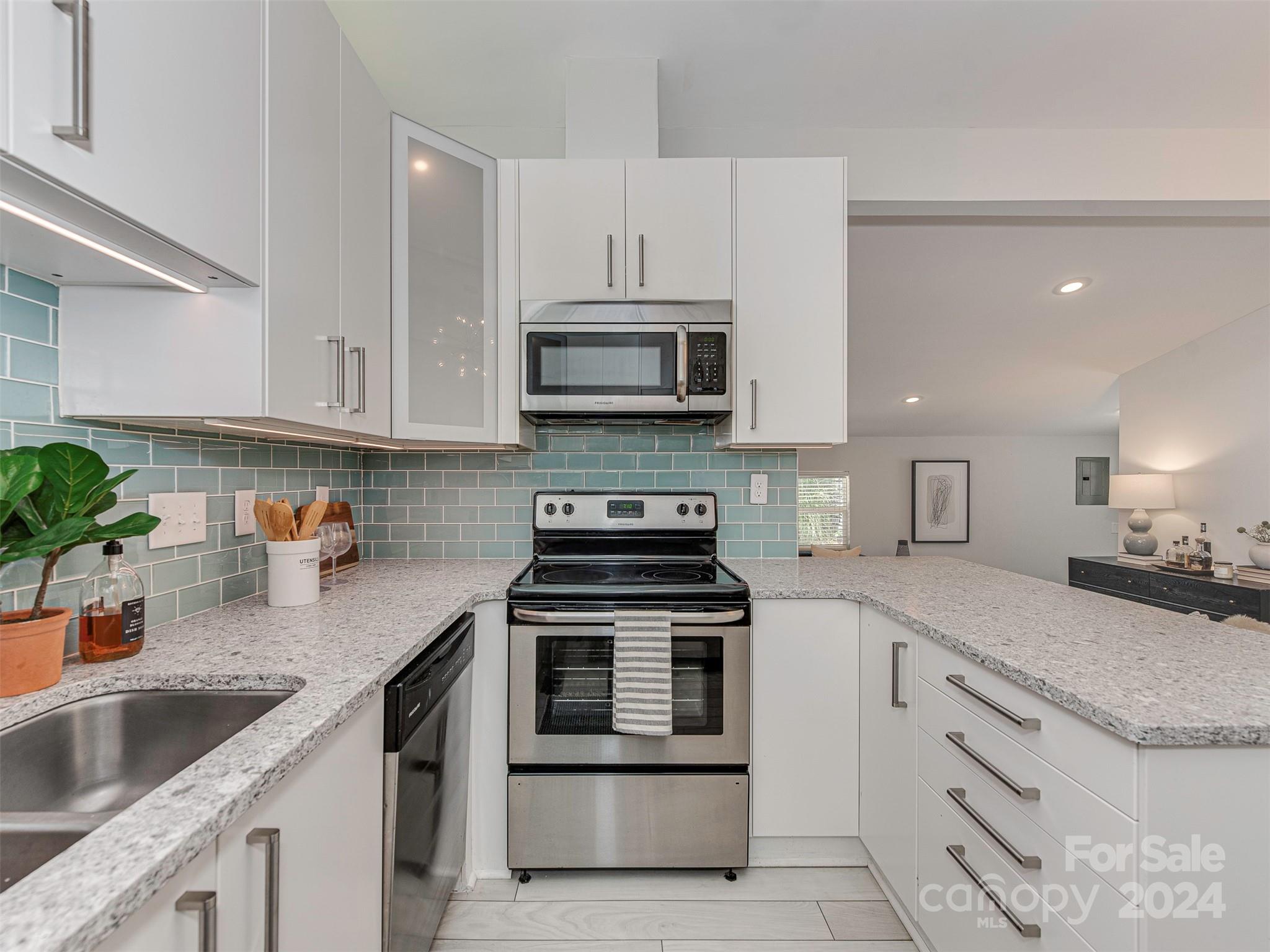 5541 Toano Road Charlotte, NC 28215 - Photo 10 of 35 a kitchen with granite countertop a stove sink and cabinets