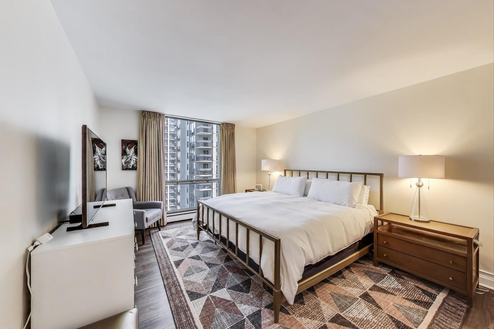 1310 North Ritchie Court, Unit 9D Chicago, IL 60610 - Photo 12 of 27 a bedroom with a bed wooden floor and window