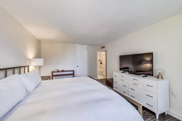 a bedroom with a bed and a flat screen tv