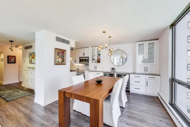 a view of a kitchen with a table and a clock on the wall