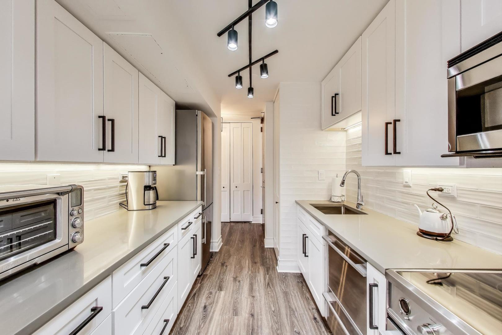 1310 North Ritchie Court, Unit 9D Chicago, IL 60610 - Photo 10 of 27 a kitchen with stainless steel appliances a sink stove and refrigerator