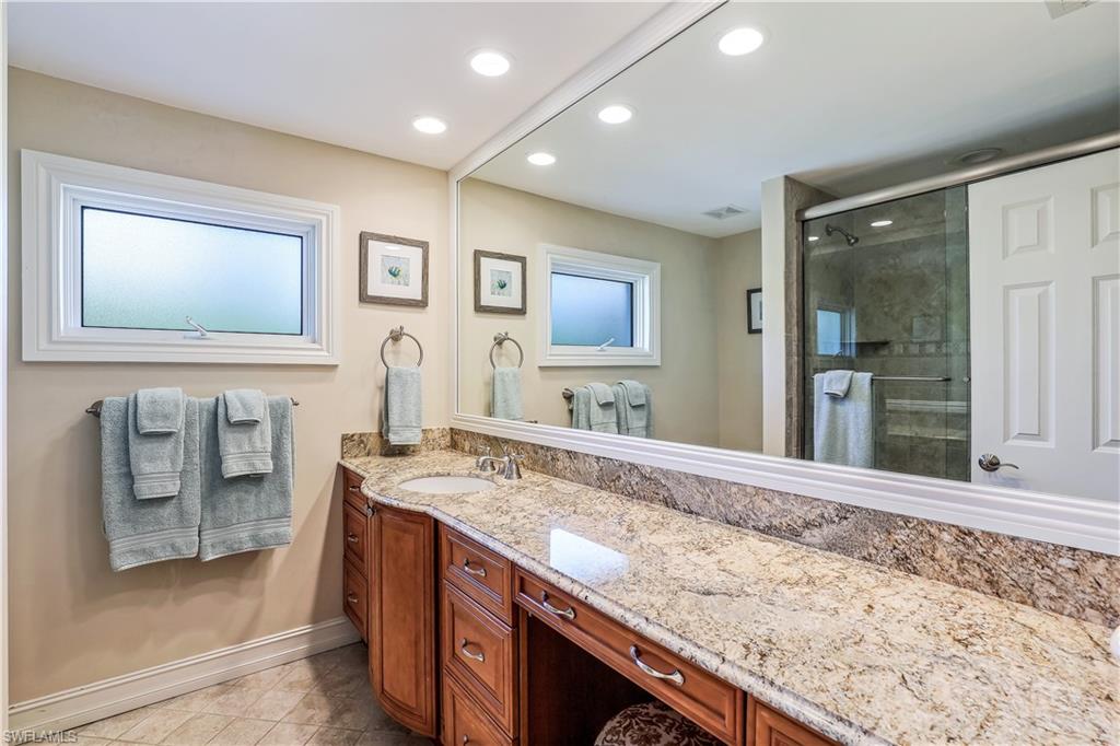 635 Anchor Rode Drive Naples, FL 34103 - Photo 28 of 50 a spacious bathroom with a granite countertop sink and a mirror