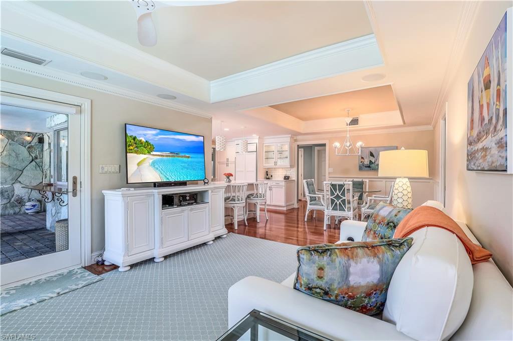 635 Anchor Rode Drive Naples, FL 34103 - Photo 9 of 50 a living room with furniture a flat screen tv and a floor to ceiling window