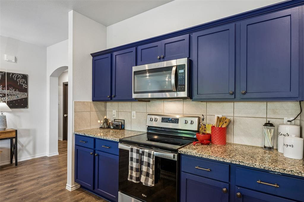 802 Rustic Way Royse City, TX 75189 - Photo 12 of 38 a kitchen with stainless steel appliances granite countertop wooden cabinets and a stove top oven