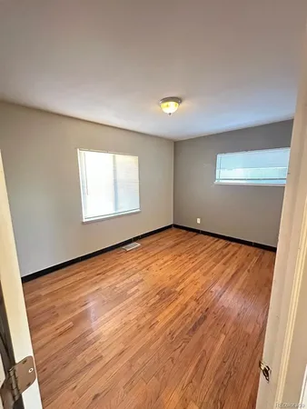 an empty room with wooden floor and closet