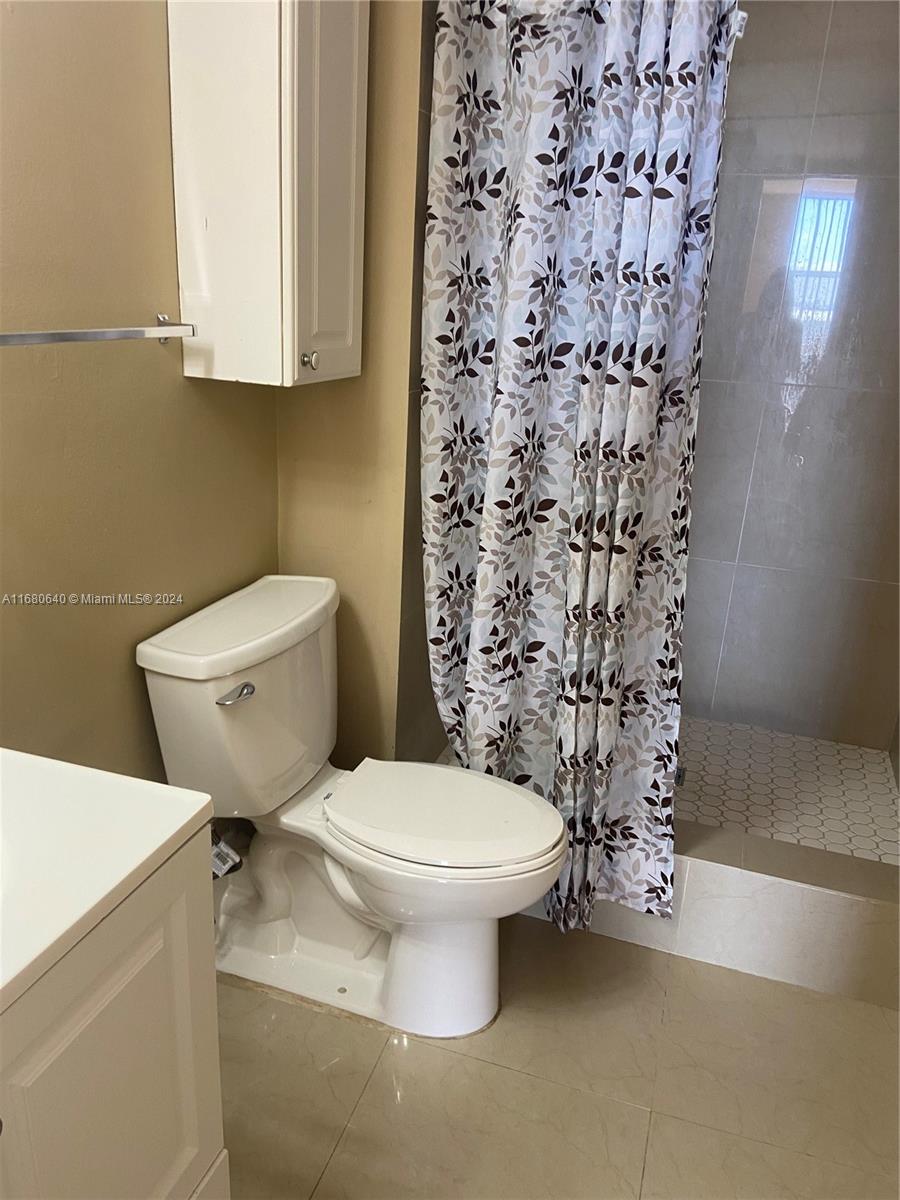 13499 Biscayne Boulevard, Unit 1506 North Miami, FL 33181 - Photo 6 of 11 a white toilet sitting next to a shower curtain