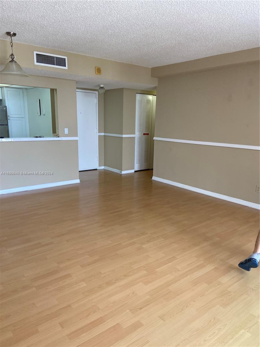 13499 Biscayne Boulevard, Unit 1506 North Miami, FL 33181 - Photo 9 of 11 a view of an empty room with wooden floor and windows