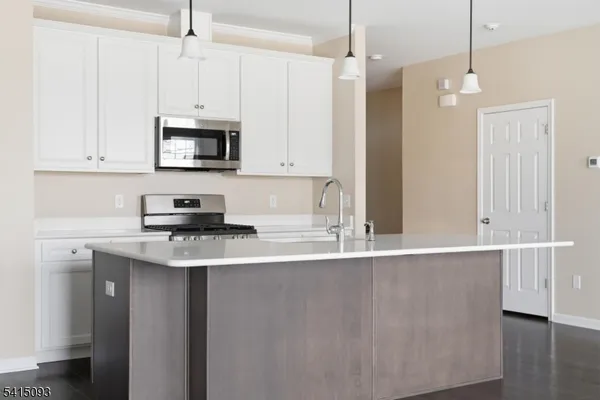 a kitchen with stainless steel appliances a sink a stove a microwave and cabinets