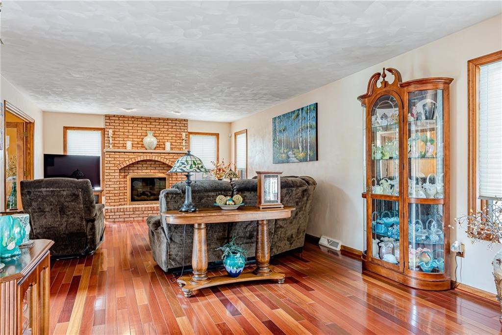 612 Rembrandt Circle Irwin, PA 15642 - Photo 8 of 32 a living room with furniture a fireplace and a flat screen tv