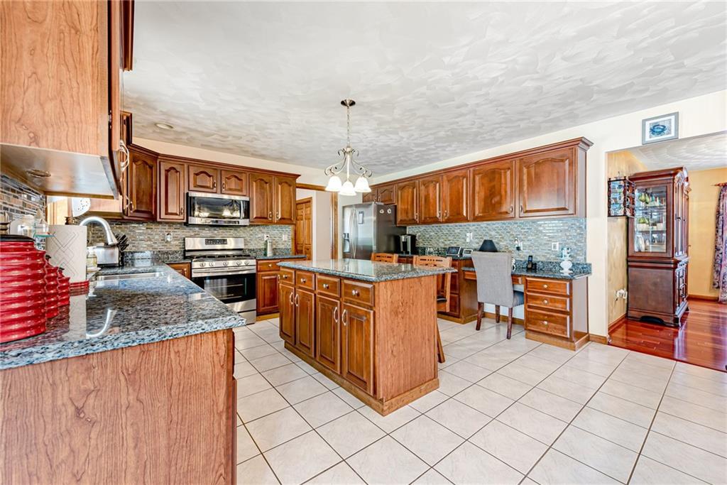 612 Rembrandt Circle Irwin, PA 15642 - Photo 9 of 32 a kitchen with stainless steel appliances granite countertop a stove a sink and a refrigerator