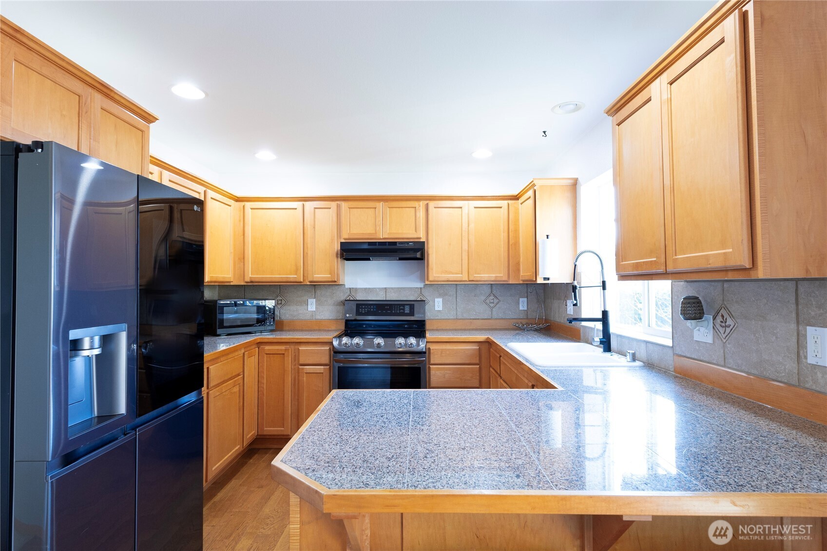 1877 Emerald Way Lynden, WA 98264 - Photo 14 of 33 a kitchen with stainless steel appliances granite countertop a refrigerator a stove top oven a sink and dishwasher