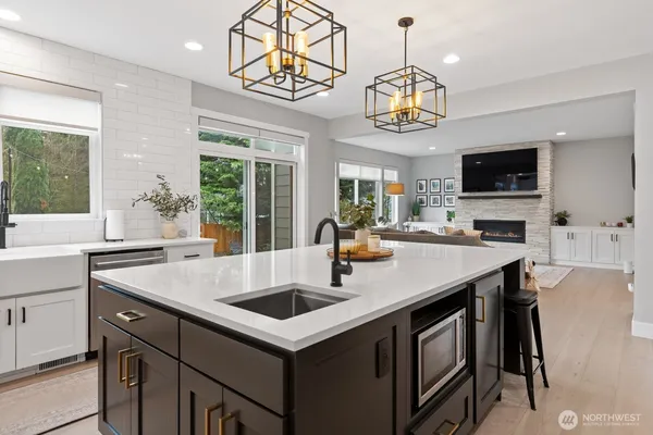a kitchen with a sink a counter space and a view of living room