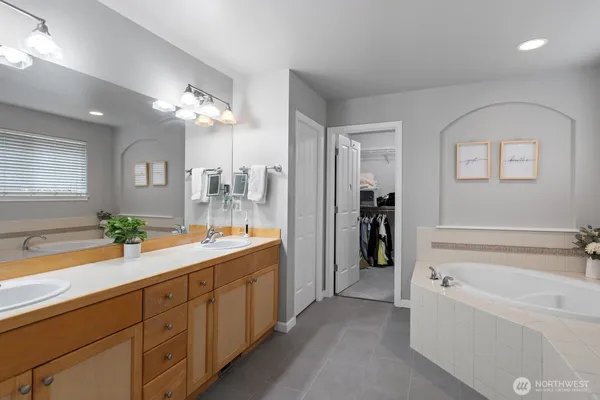 a spacious en suite bathroom with a granite countertop tub and a mirror