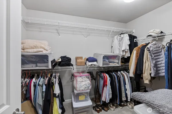 a view of walk in closet with clothes and shoes