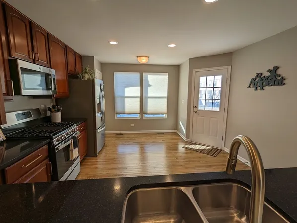 a kitchen with wooden cabinets a sink a stove and refrigerator