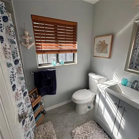 a bathroom with a toilet a sink and a window
