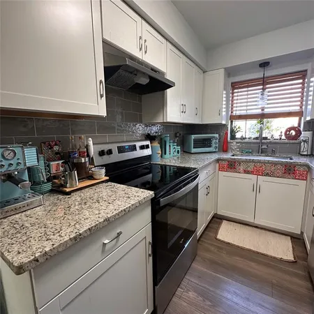 a kitchen with a stove a sink and a microwave
