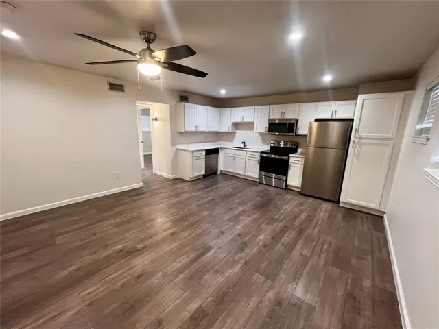 a view of kitchen with stainless steel appliances refrigerator stove microwave and cabinets