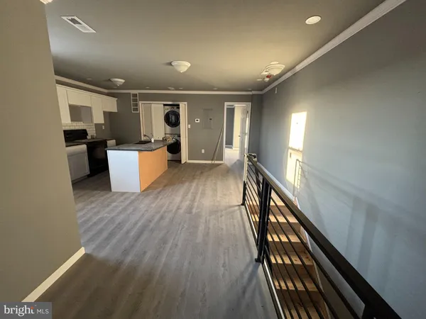 a view of a kitchen with furniture and wooden floor