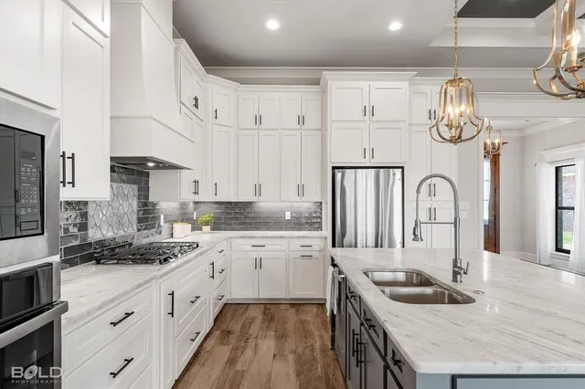 a kitchen with granite countertop a sink stainless steel appliances and cabinets