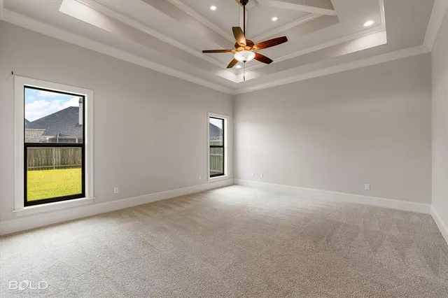an empty room with windows and fan