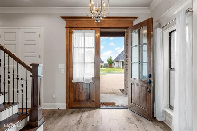 a view of a hallway with wooden floor and door