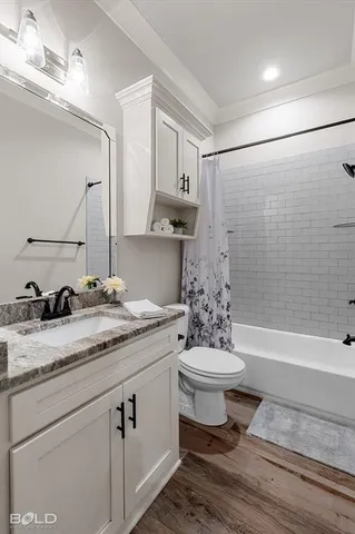 a bathroom with a granite countertop sink toilet mirror vanity and bathtub