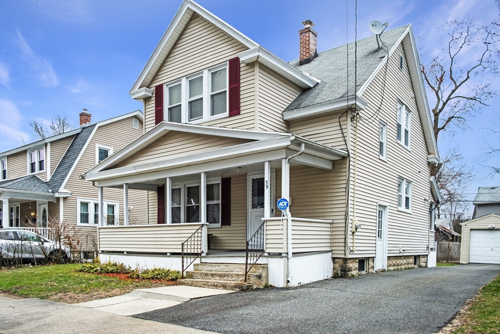 a white house with a small yard and large parking space