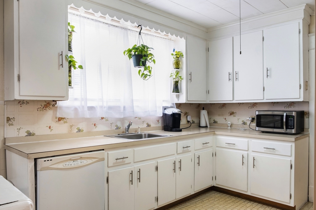 39 Meredith Street Springfield, MA 01108 - Photo 9 of 36 a kitchen with granite countertop white cabinets white appliances and a potted plant