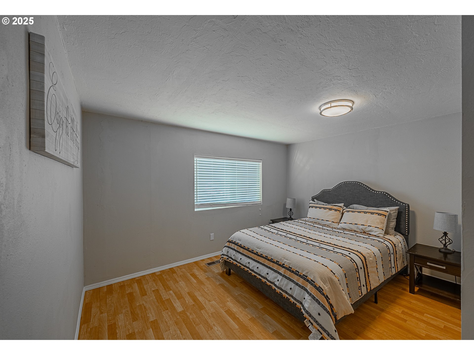 150 North 11th Street Lakeside, OR 97449 - Photo 20 of 37 a bedroom with a bed and a painting on the wall