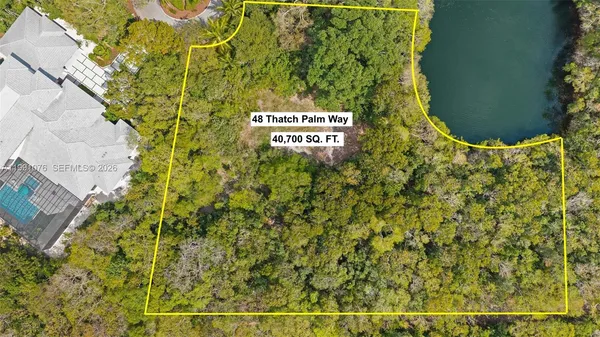 an aerial view of a house with a yard and lake view