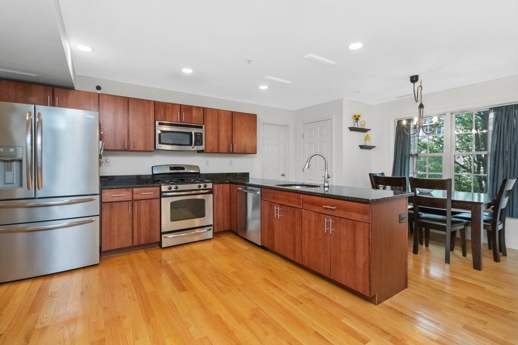 29 Spruce Street, Unit 23 Waltham, MA 02453 - Photo 4 of 26 a kitchen with stainless steel appliances a stove a sink and a refrigerator