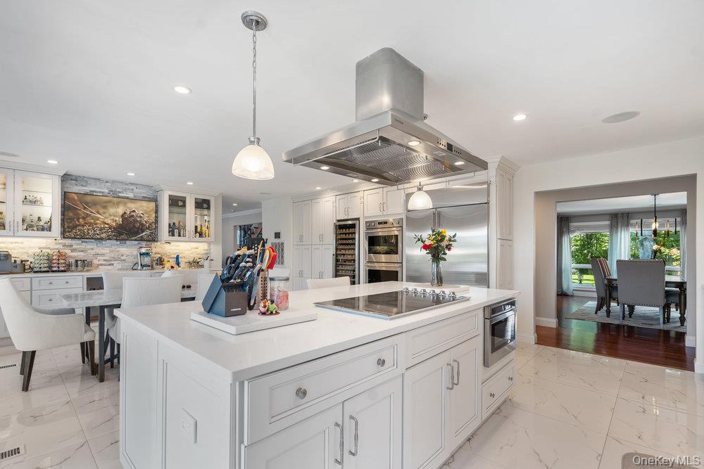 5 Coon Hollow Road Lloyd Harbor, NY 11743 - Photo 11 of 43 a kitchen with stainless steel appliances kitchen island granite countertop a sink a stove and a large mirror