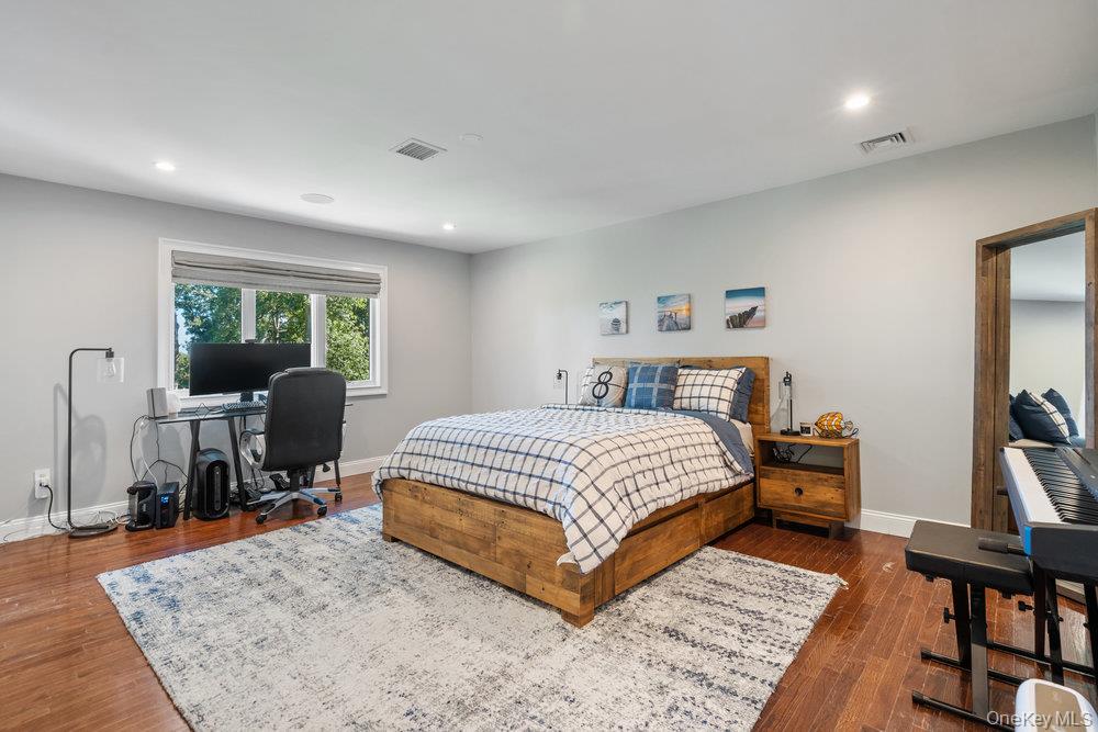 5 Coon Hollow Road Lloyd Harbor, NY 11743 - Photo 24 of 43 a bedroom with a bed a large window and work place