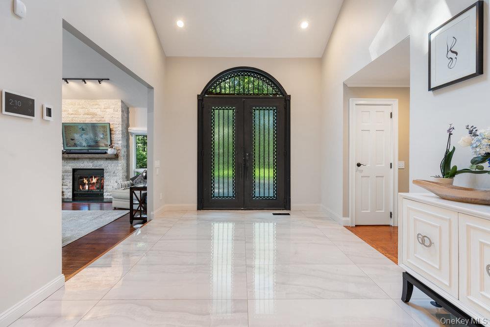 5 Coon Hollow Road Lloyd Harbor, NY 11743 - Photo 4 of 43 a hallway with windows and a fireplace