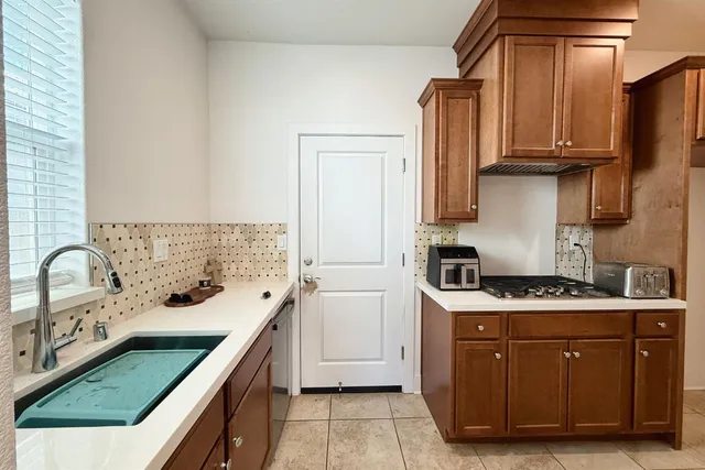 a kitchen with stainless steel appliances granite countertop a sink and a stove