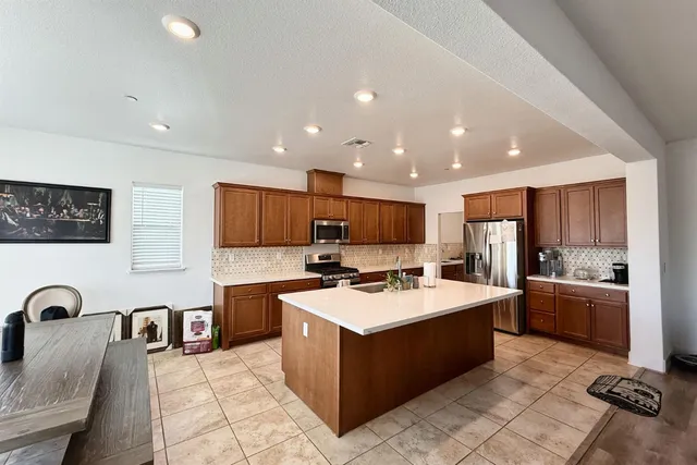 a open kitchen with stainless steel appliances granite countertop a stove top oven a sink a counter top space and cabinets