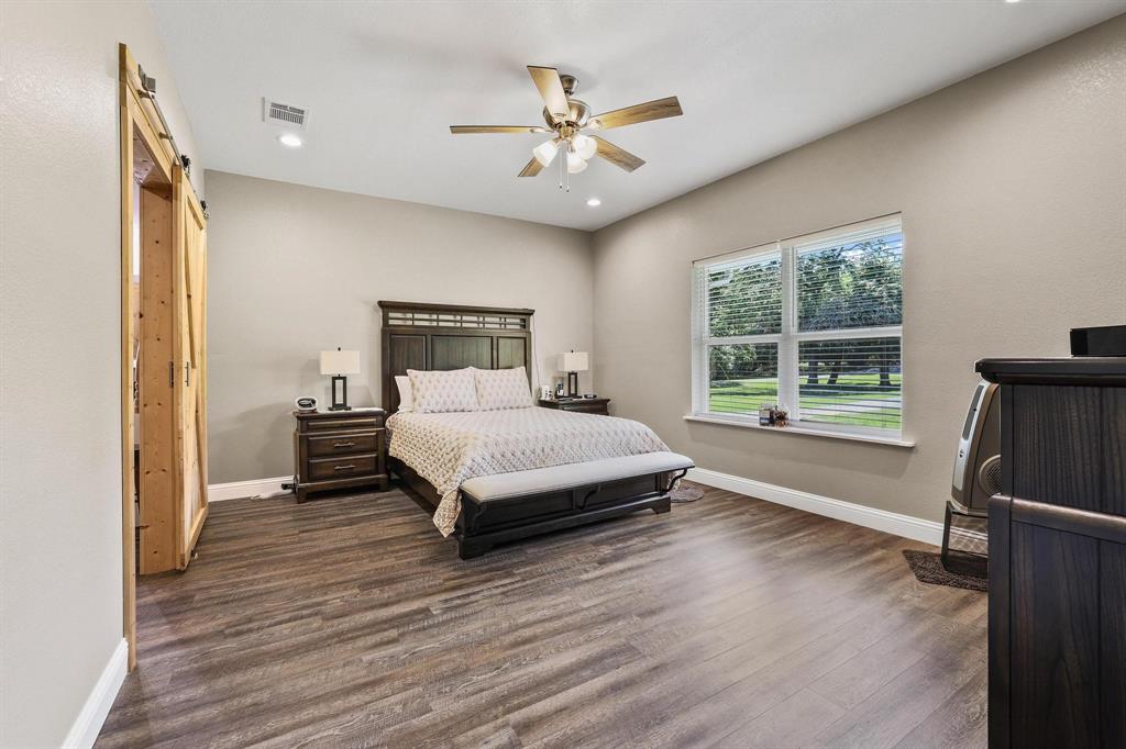 2658 Oak Ridge Road Denison, TX 75021 - Photo 16 of 37 a spacious bedroom with a bed and a large window with outer view