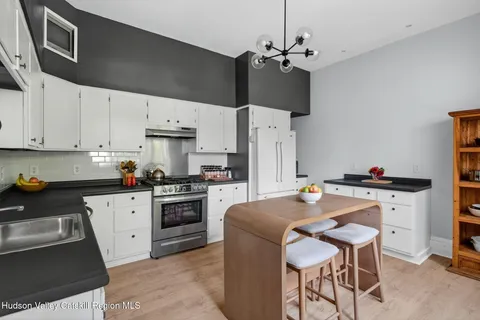 a kitchen with cabinets a counter and chairs