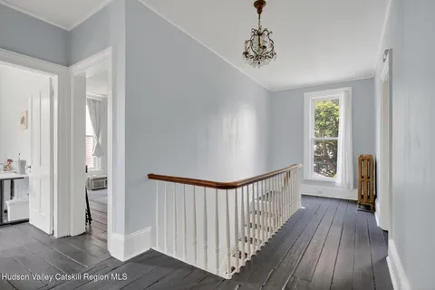 a view of a hallway view with wooden floor and staircase