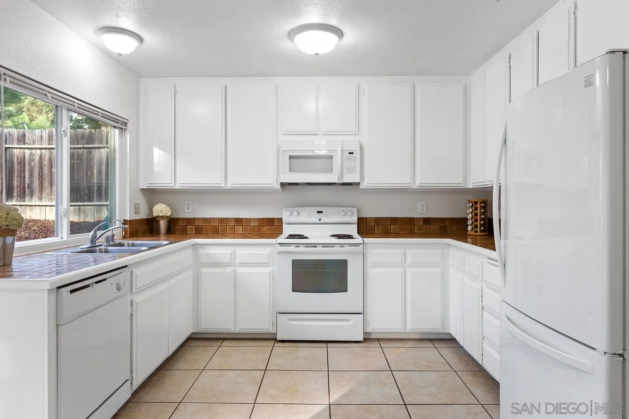 395 Compass Road Oceanside, CA 92054 - Photo 8 of 25 a kitchen with a stove sink and cabinets