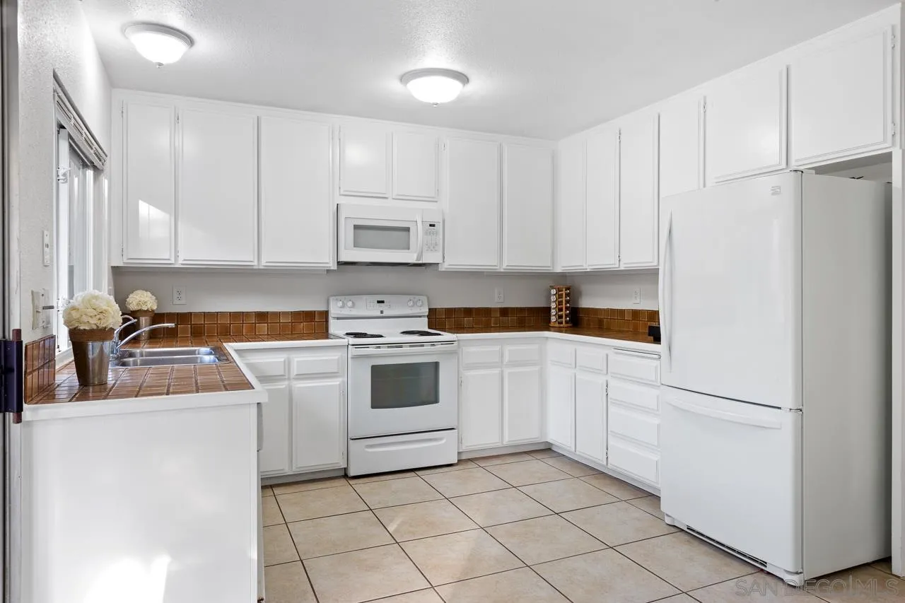 395 Compass Road Oceanside, CA 92054 - Photo 9 of 25 a kitchen with appliances a sink and cabinets