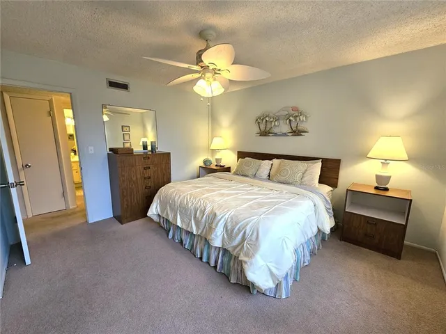 a spacious bedroom with a bed and a chandelier