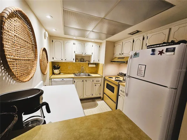 a kitchen with white cabinets and white appliances