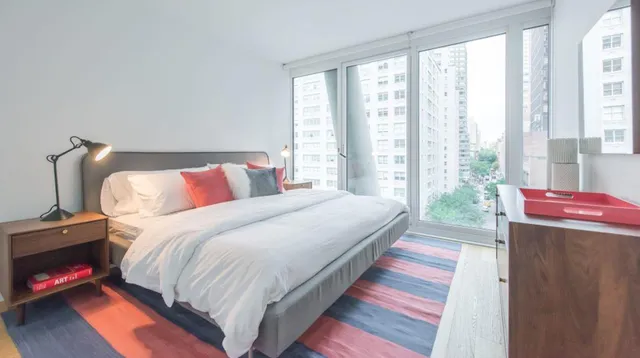 a bedroom with bed and large windows