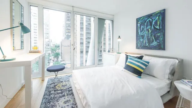 a spacious bedroom with a bed and a large window with outer view