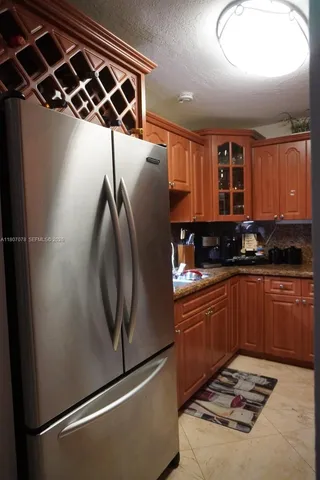 a kitchen with stainless steel appliances granite countertop a refrigerator and a sink