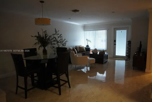 a living room with furniture a dining table and a potted plant
